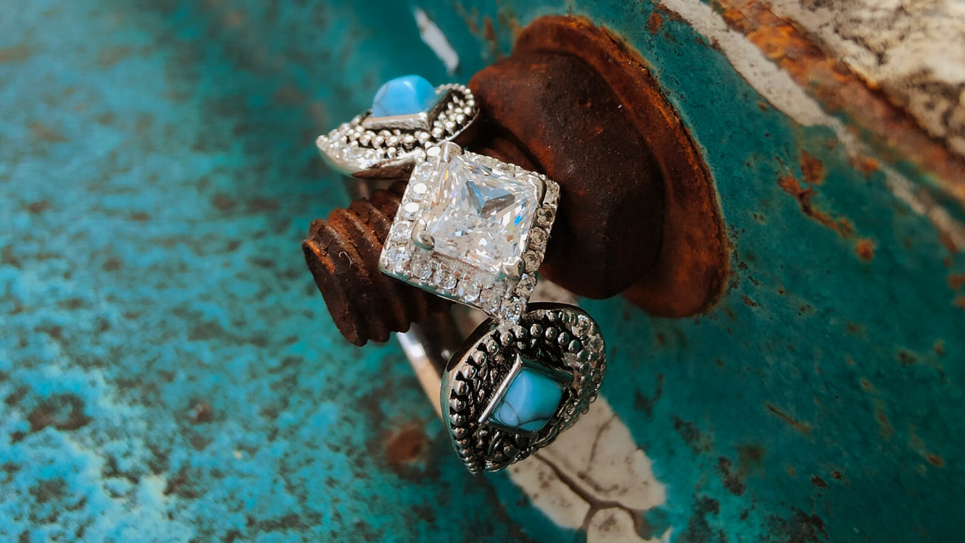 Western turquoise ring set with a square-cut clear center stone