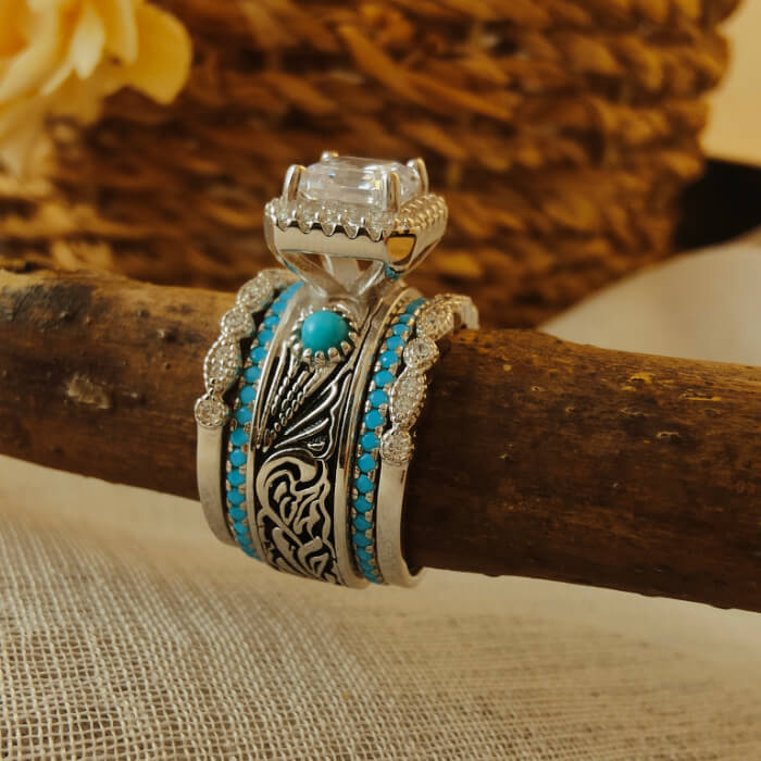 Intricate turquoise and diamond bridal set displayed on a rustic wooden branch.