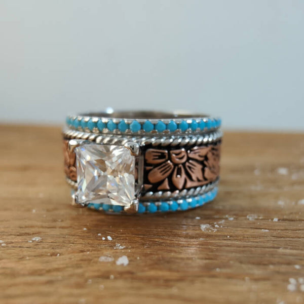 Rose gold princess cut engagement ring with turquoise stones and floral details