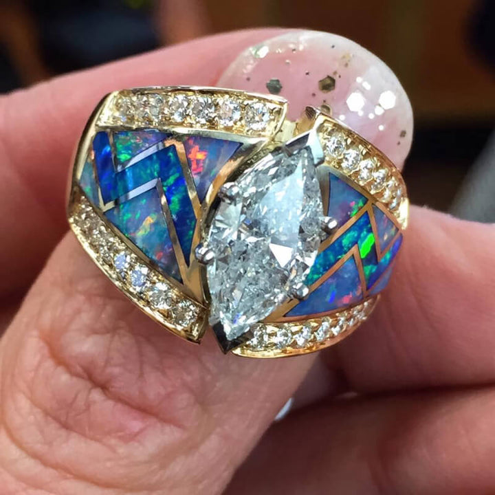 Stunning marquise cut blue opal and diamond ring with gold zigzag design.