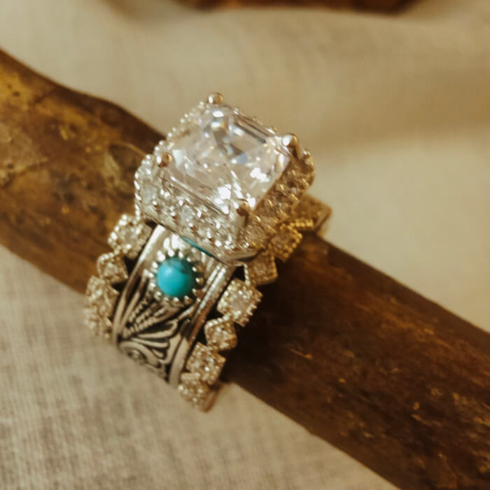 Radiant cut diamond and turquoise silver ring set with intricate detailing.