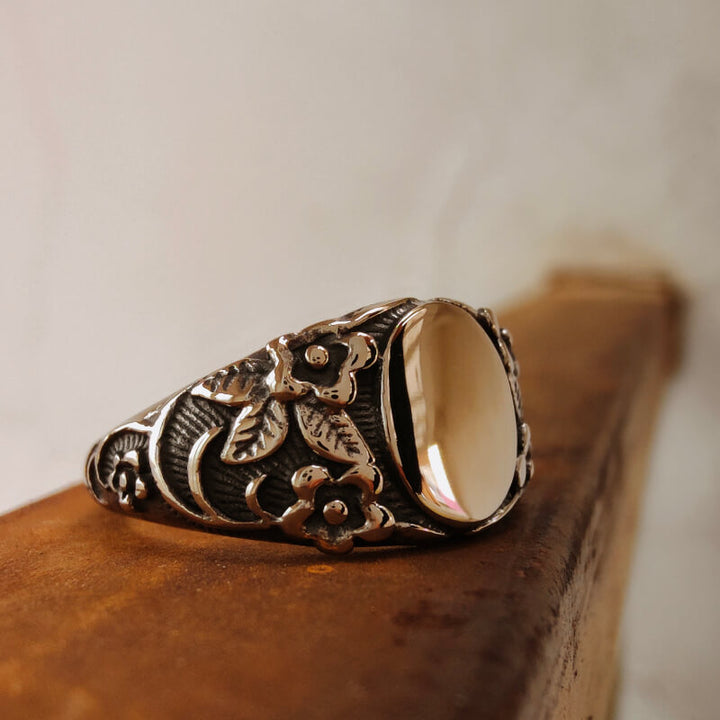Flower engraved silver band ring with a large polished gemstone