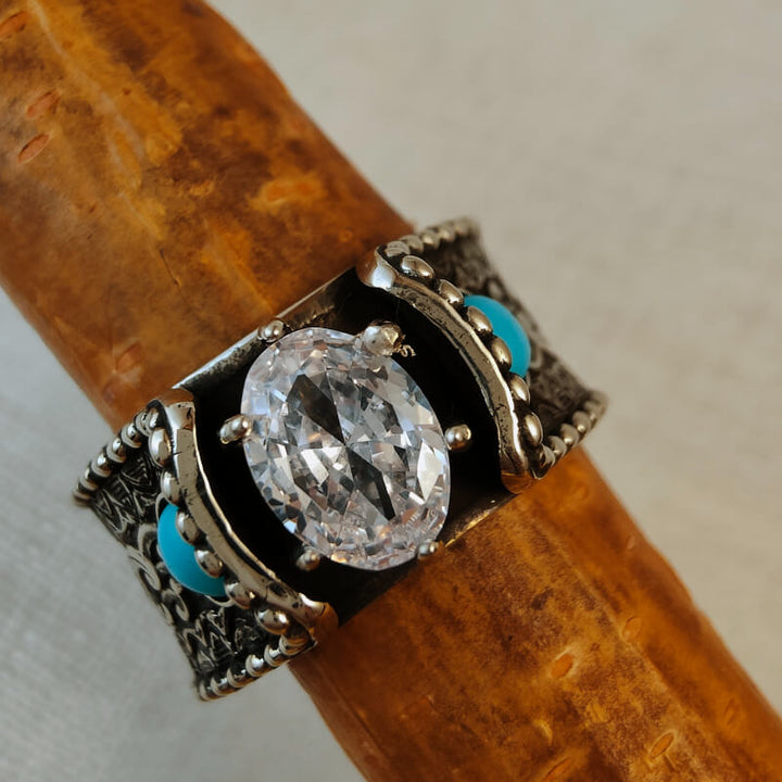 Turquoise and diamond flower engagement ring on wooden surface