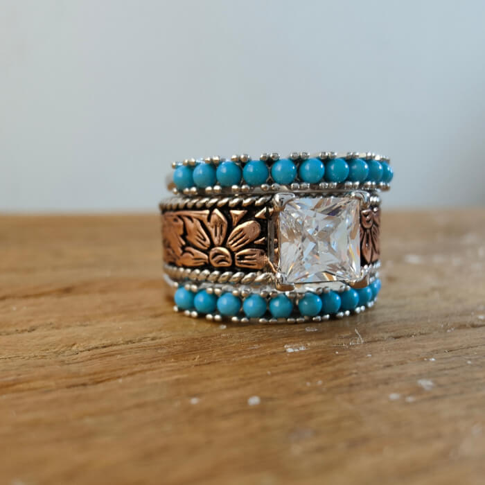 Rose gold princess cut ring featuring turquoise beads and floral details.