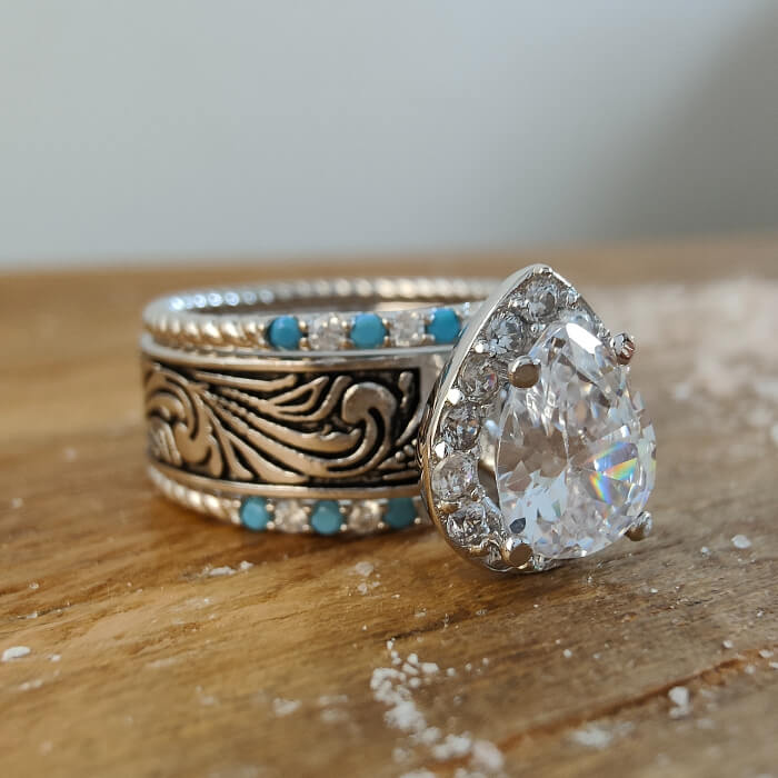 Pear-shaped diamond ring with turquoise accents on intricate silver band