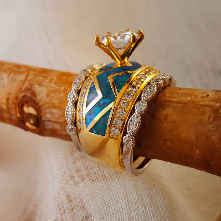 Gold ring with turquoise inlay and diamond accents atop a wooden surface