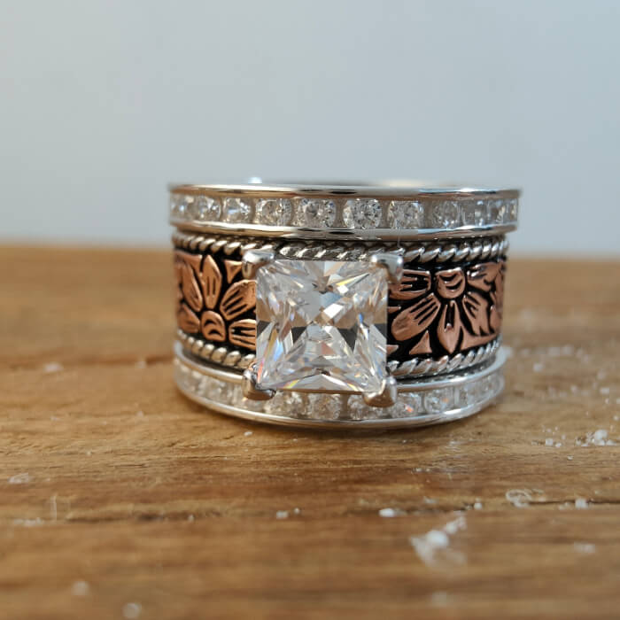 Floral engraved western-style ring with a princess cut diamond center and silver accents.