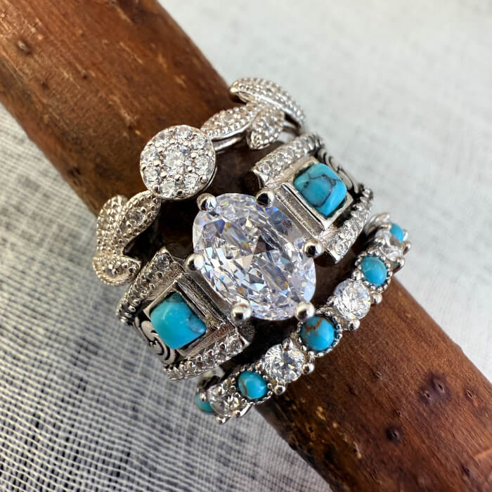 Stack of three vintage turquoise and diamond rings with intricate designs