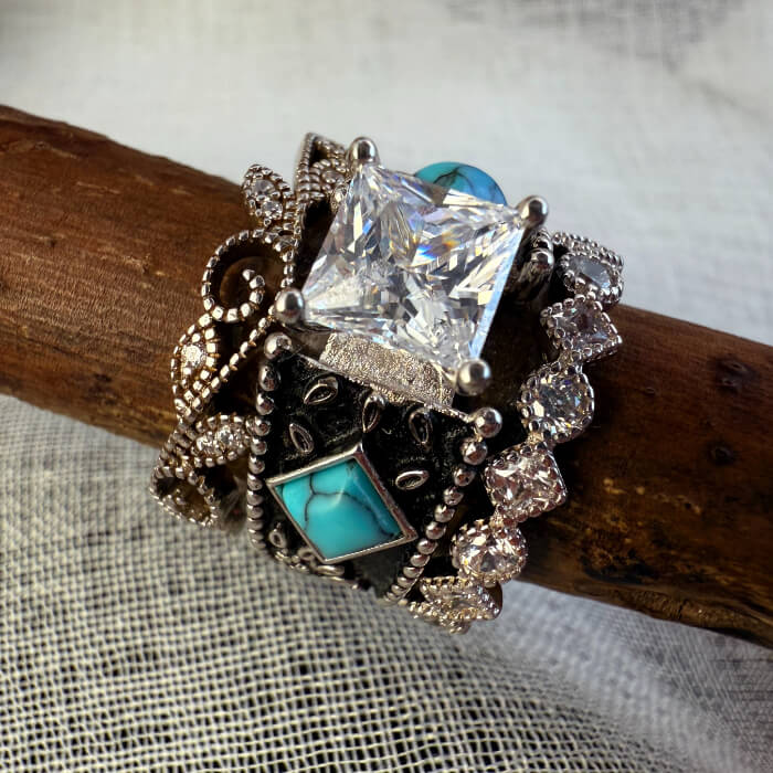 Three vintage western rings with turquoise and diamond on a wooden surface.