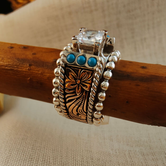 Square diamond ring set with intricate flower design and turquoise stones.