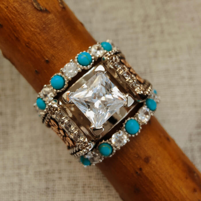 Engagement ring with moissanite center, turquoise stones, and decorative silver band