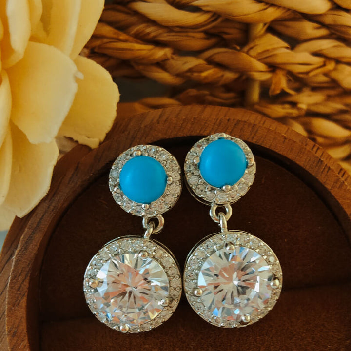 Turquoise and diamond drop earrings with polished oxidized finish.