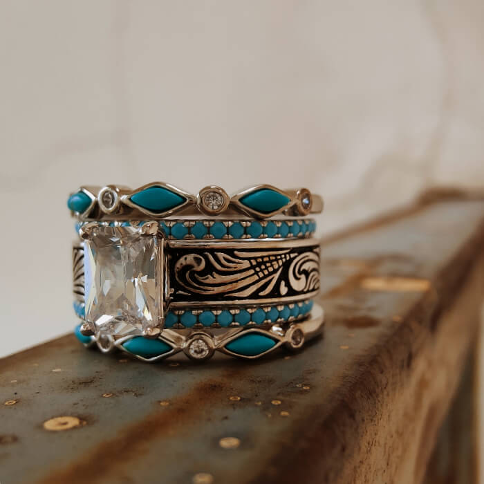 Five-piece turquoise wedding ring set with emerald cut stone and floral engravings.