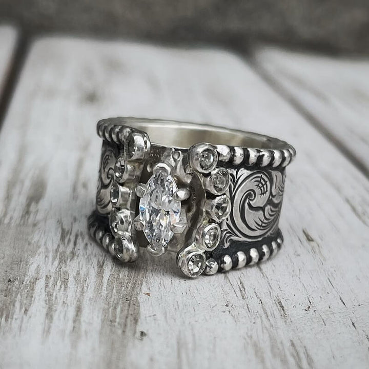 Wide band silver engagement ring with marquise diamond and floral engravings