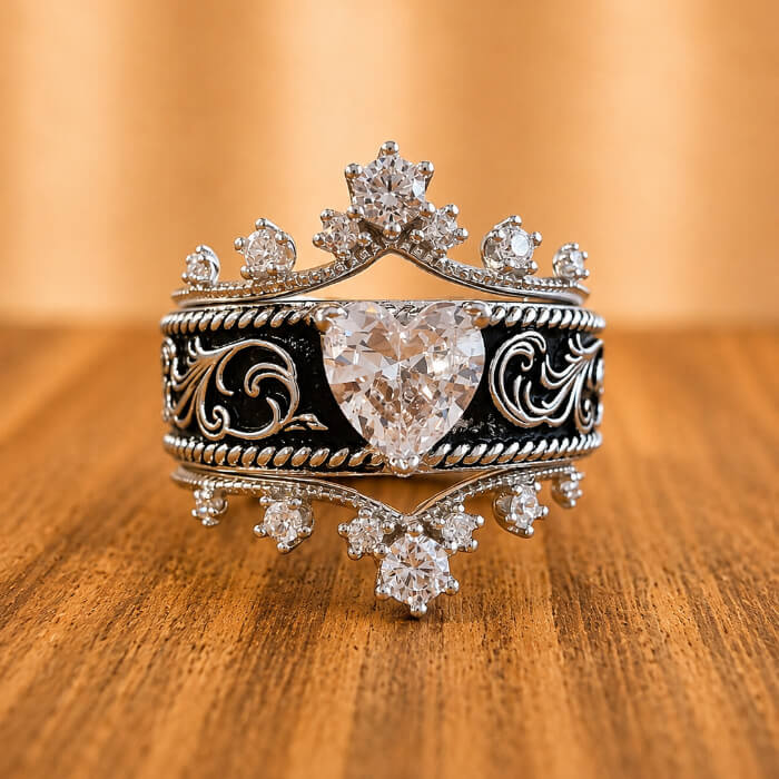 Front view of three-piece western bridal ring set with heart-shaped clear center and black scroll engraving