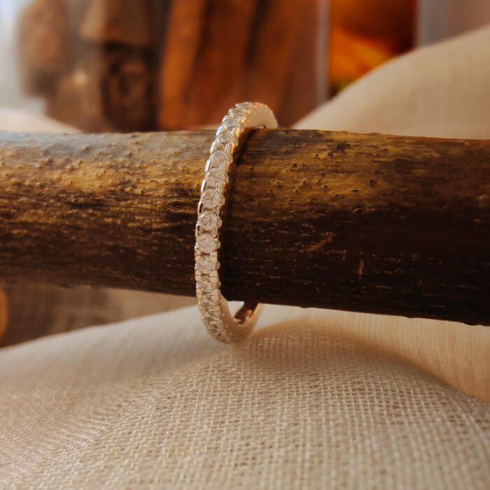 Moissanite silver stacking ring on rustic wood display