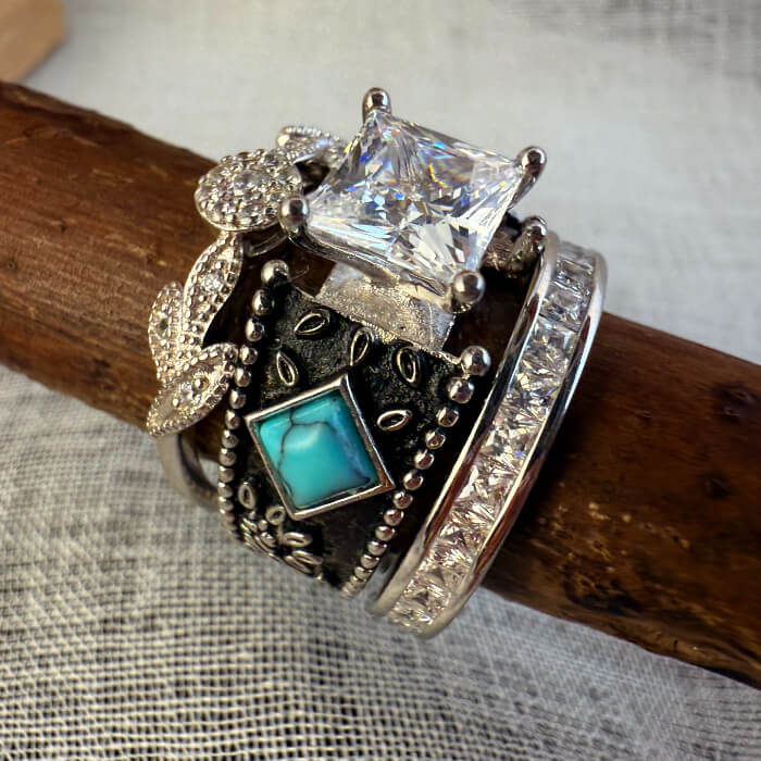 Turquoise engagement ring trio with square crystal and decorative silver detailing.