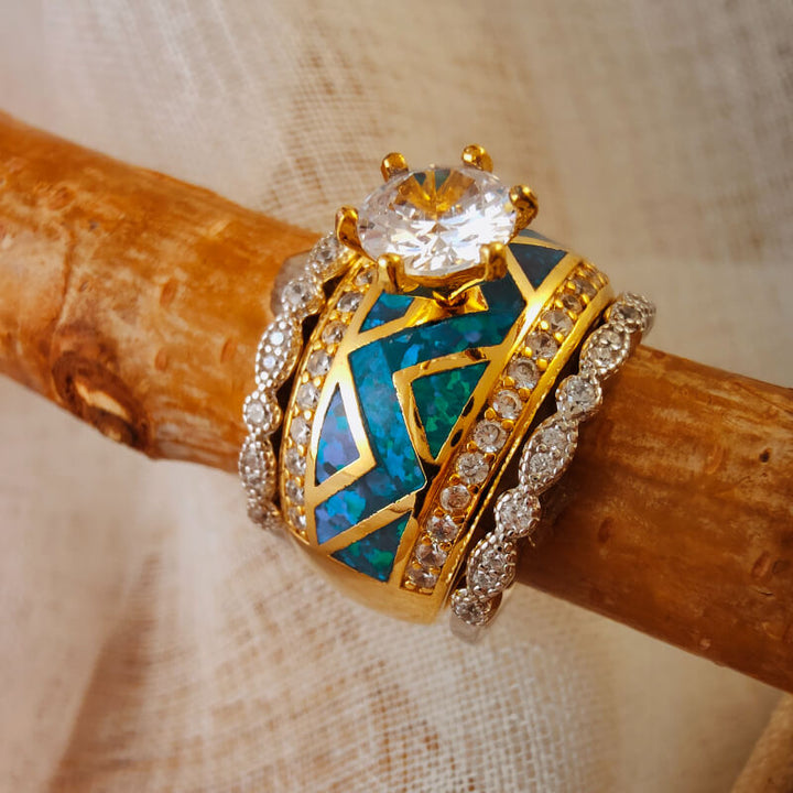 Gold ring with large opal stone, turquoise inlays, and diamond accents