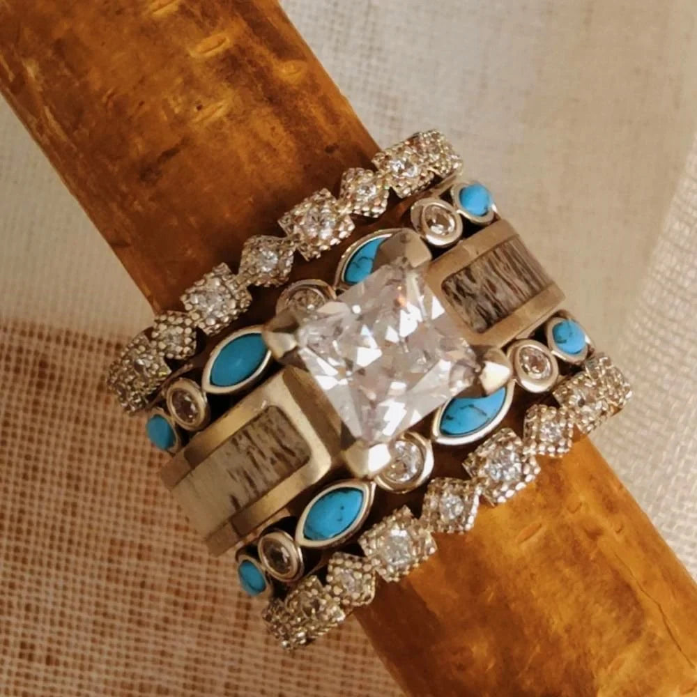 Top view of a five-piece ring stack with a square clear center, blue accents and clear-stone bands