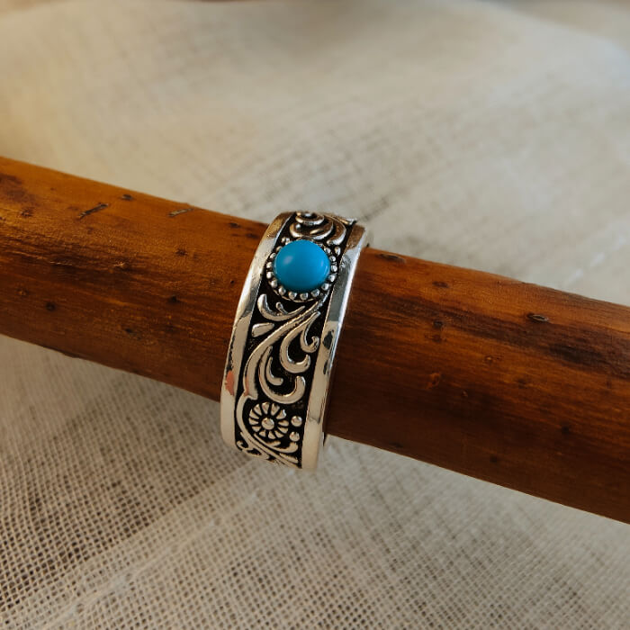 Western-style steel ring with flower designs and blue turquoise centerpiece