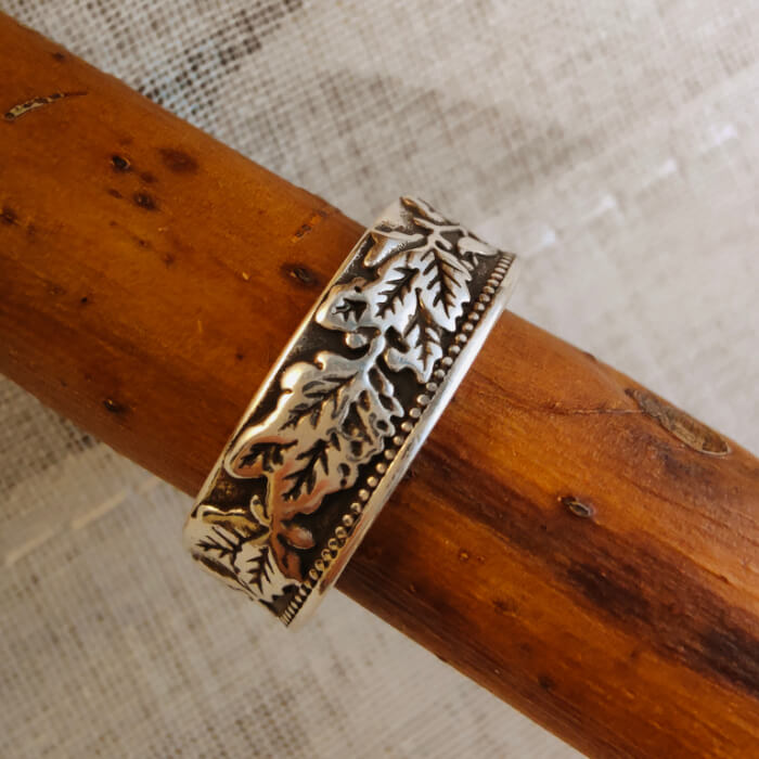 Detailed leaf engravings on a 6mm steel Western band ring for men.