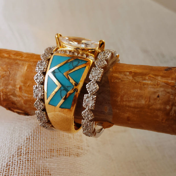 Gold ring set with marquise cut turquoise and diamond accents on wood