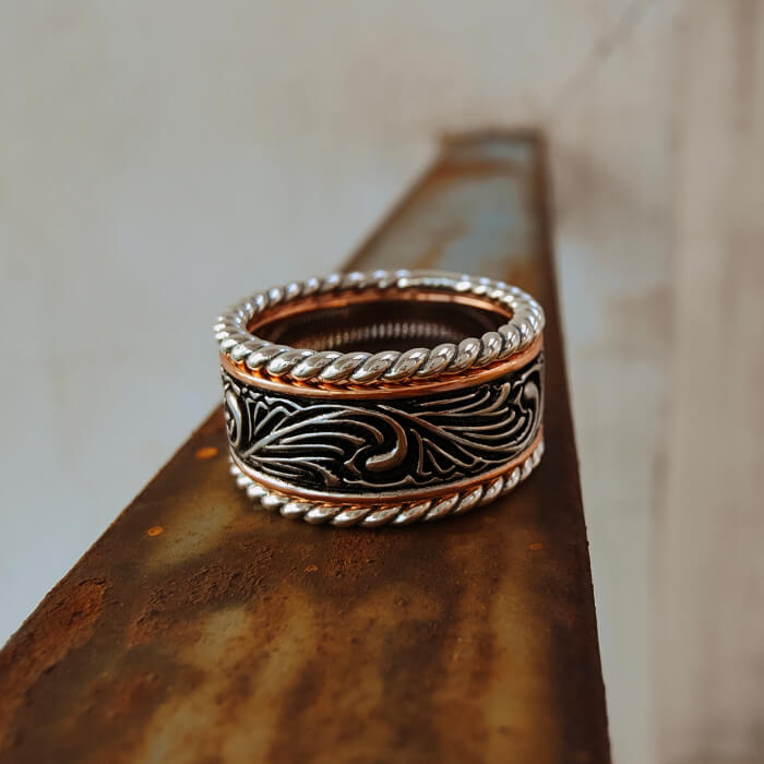 Western band ring with intricate engravings in silver and rose gold