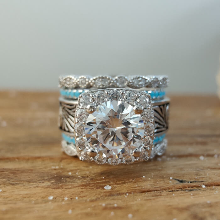 Vintage round diamond engagement ring with floral engravings and turquoise accents.