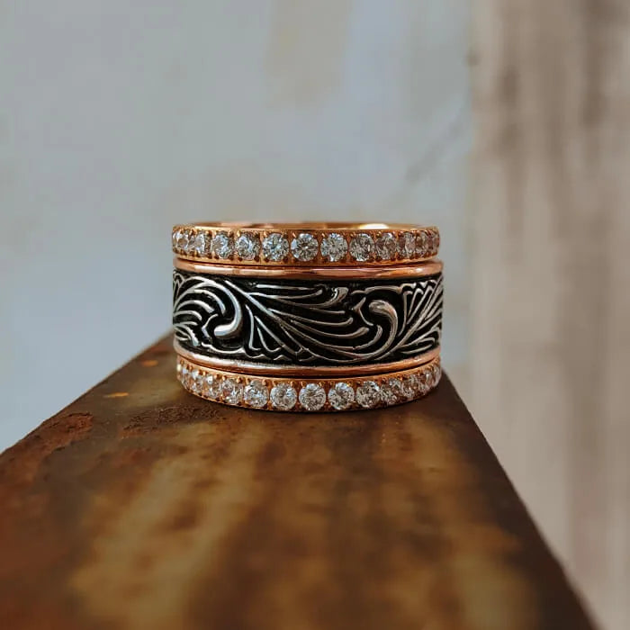 Front view of three stacked Western bands with floral engraving and clear accents