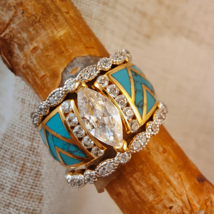 Gold-accented turquoise ring with diamond embellishments and wave pattern