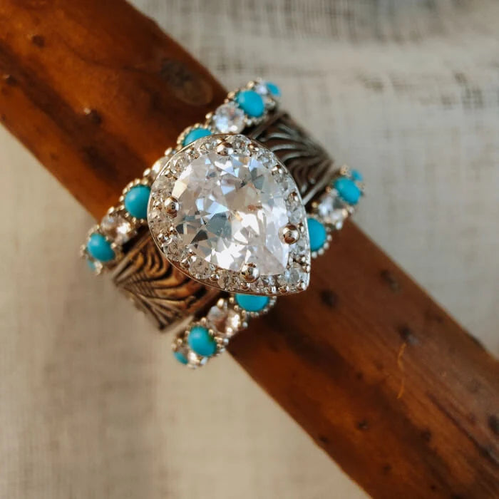 Front view of pear-cut zircon ring with engraved silver and turquoise stacking bands