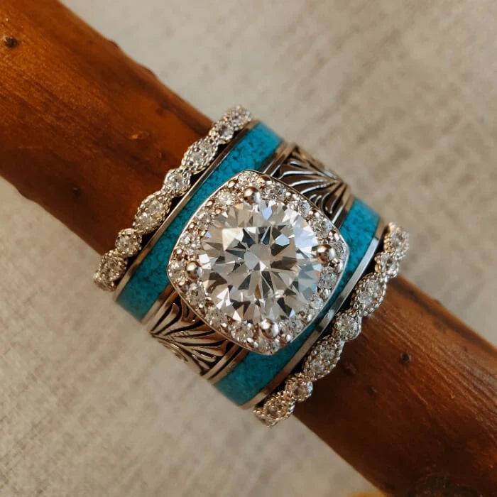 Front view of a Western ring stack with a round clear center, blue inlay bands and clear accent bands