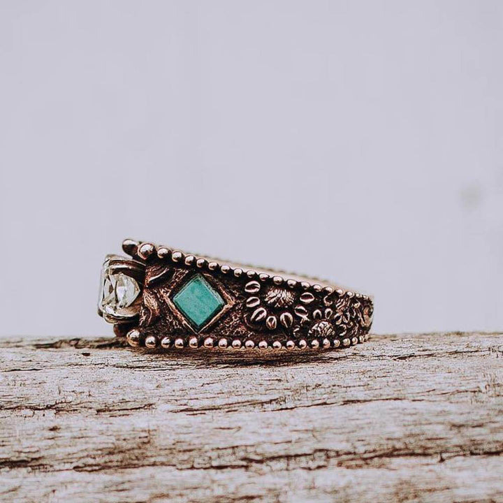 Engraved turquoise engagement ring with diamond accent on vintage-style band.