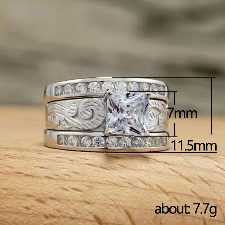 Wide band diamond ring with zircon center and intricate engraving on wooden surface