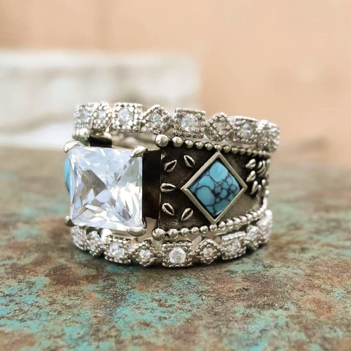 Vintage-inspired ring with square zircon and turquoise accents on textured background
