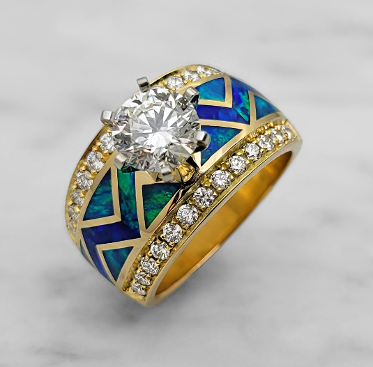 Gold band engagement ring featuring a large diamond and blue opal inlay design