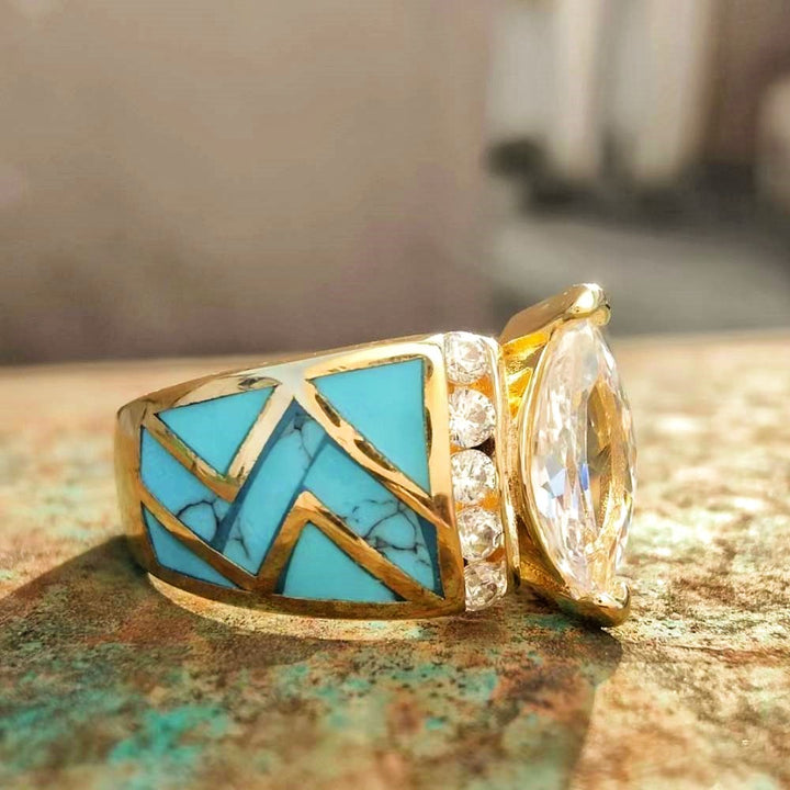 Gold engagement ring with marquise cut diamond and turquoise inlay design