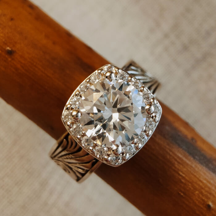 Round zircon engagement ring with diamond halo on ornate silver band