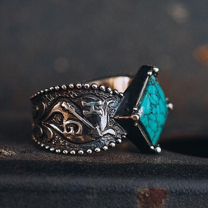 Western turquoise ring featuring square stone and floral design in silver.
