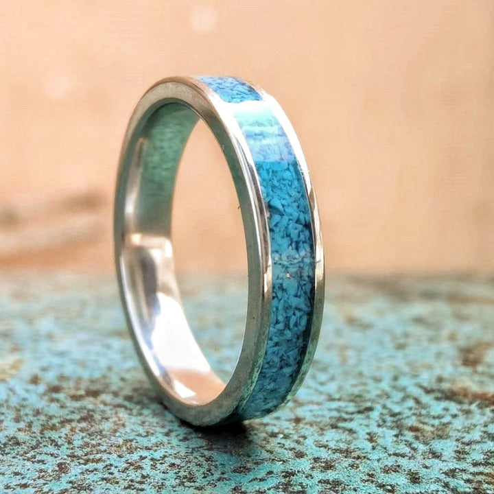 Sleek sterling silver band ring with crushed turquoise inlay on textured surface