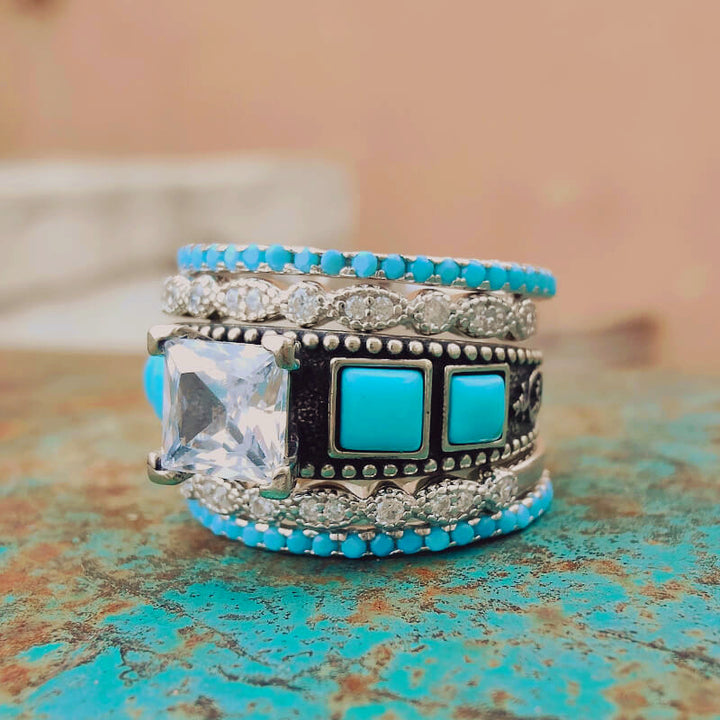 Intricate silver ring set featuring turquoise squares and a large zircon stone