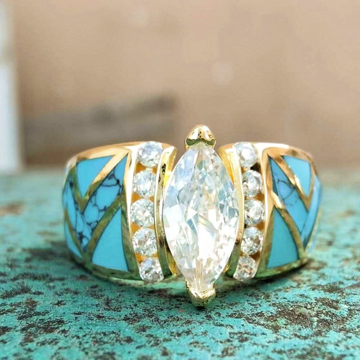Gold engagement ring with marquise diamond center and turquoise inlay accents