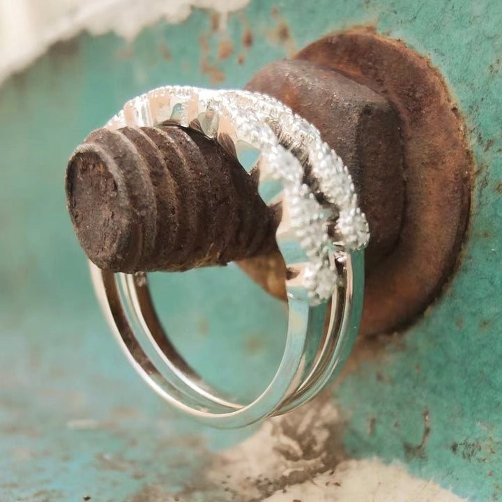 Sterling silver vintage diamond band ring resting on a rusty bolt.