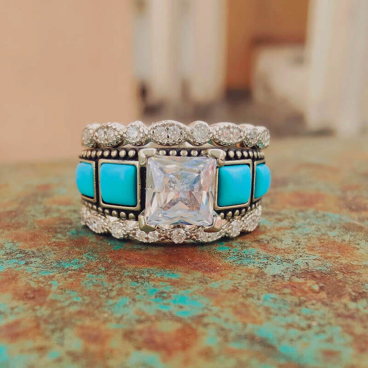 Square turquoise and diamond ring set with ornate silver band design.