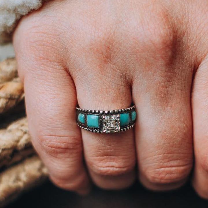 Vintage turquoise and zircon ring on hand with square diamond stone