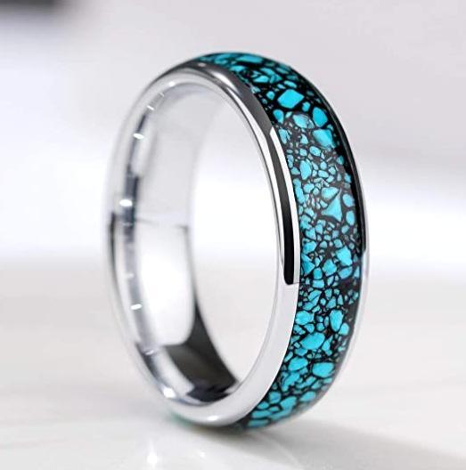 Polished stainless steel ring with turquoise inlay and intricate pattern.