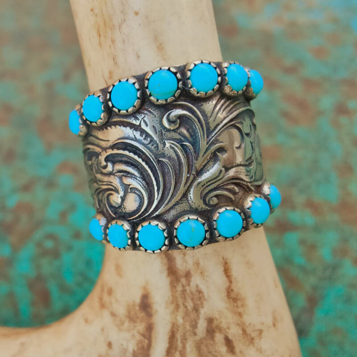 Floral silver cuff bracelet adorned with turquoise gemstones