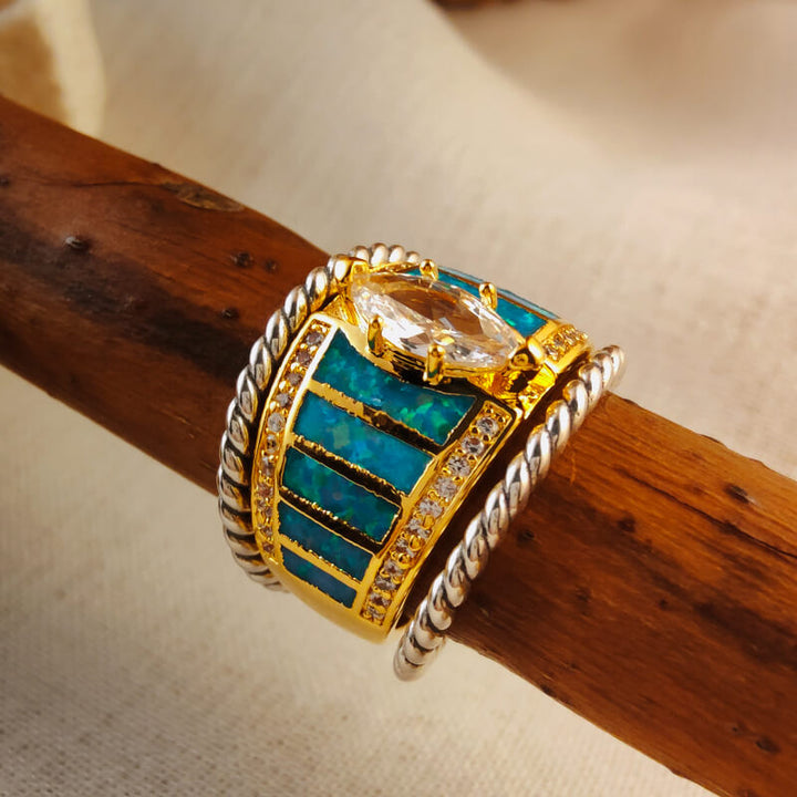 Gold engagement ring with blue opal inlay and sparkling zircon accents
