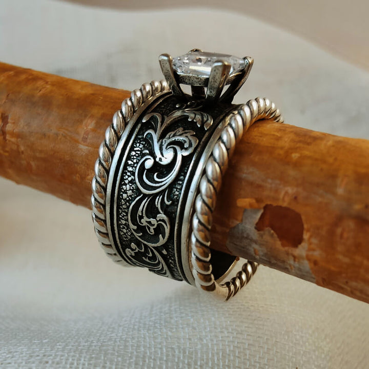 Sterling silver ring set with clear gemstone and floral engravings