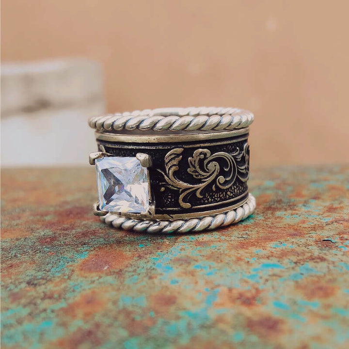 Handcrafted sterling silver ring with clear zircon and floral engravings.
